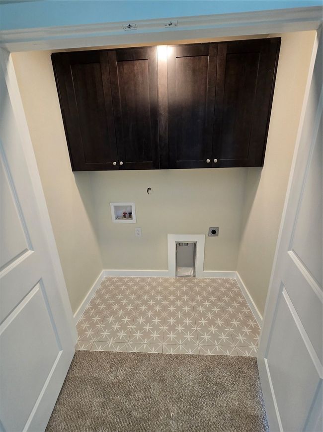 Washroom with hookup for a washing machine, hookup for an electric dryer, hookup for a gas dryer, cabinet space, and baseboards | Image 26