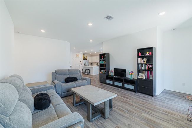Spacious family room with luxury vinyl flooring is open to the kitchen. | Image 8