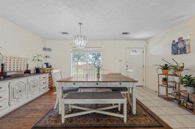 Dining room featuring an inviting chandelier, a textured ceiling, and visible vents | Image 10
