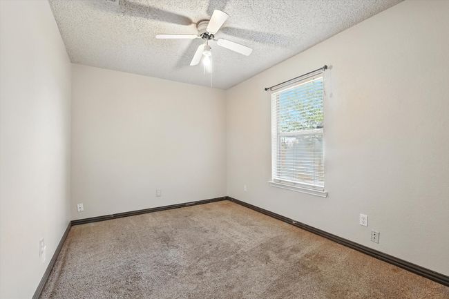 Carpeted spare room featuring a textured ceiling and a ceiling fan | Image 12
