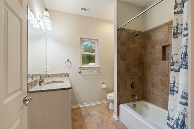 Full bath with shower / bathtub combination with curtain, vanity, visible vents, toilet, and baseboards | Image 11