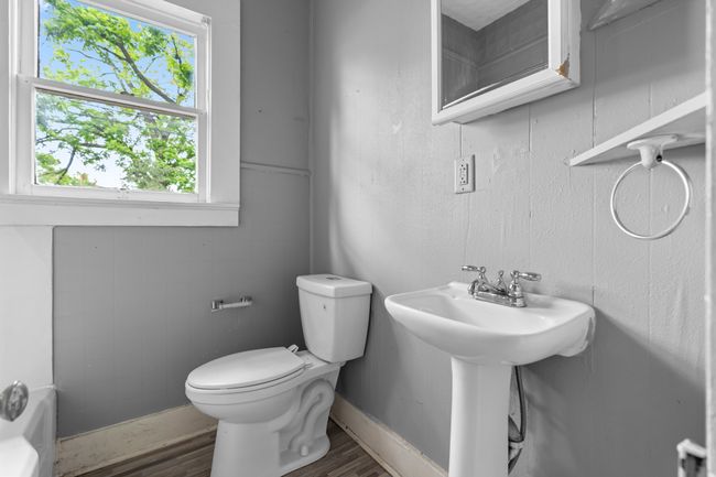 Bathroom with toilet, wood finished floors, healthy amount of natural light, and a sink | Image 30