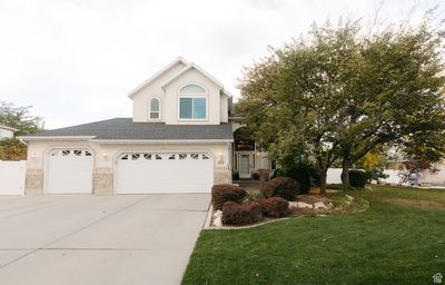 View of property featuring a front lawn and a garage | Image 1