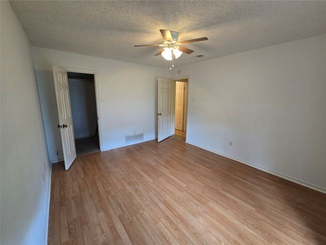 Unfurnished bedroom with light wood-style floors, a textured ceiling, and a ceiling fan | Image 18