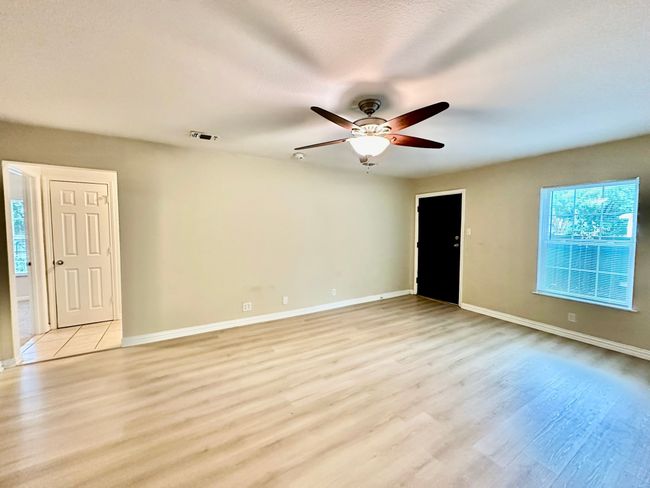 Empty room featuring ceiling fan and light wood-style floors | Image 4