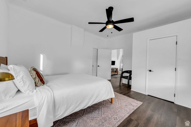 Bedroom with dark wood finished floors and ceiling fan | Image 11