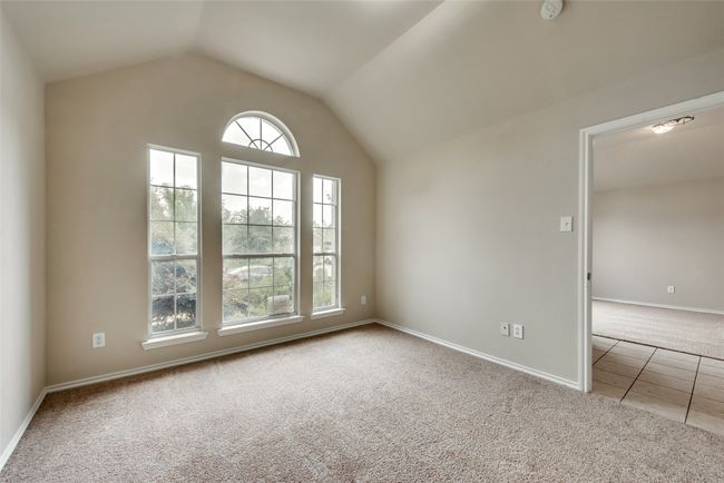 Carpeted spare room featuring vaulted ceiling, tile patterned flooring, and a smoke detector | Image 6