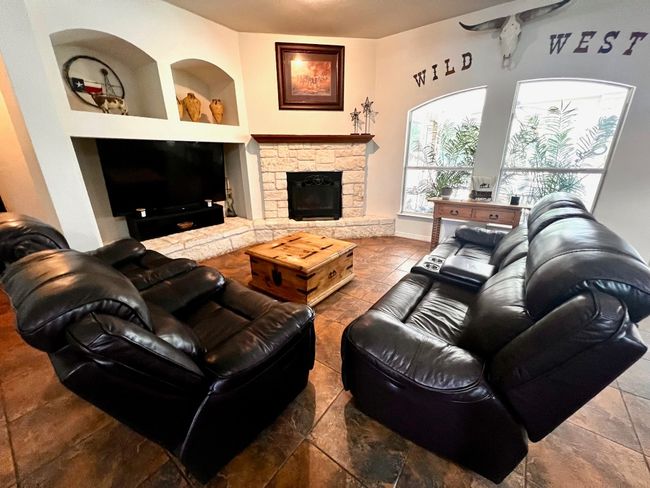 Living area featuring built in shelves and a stone fireplace | Image 10