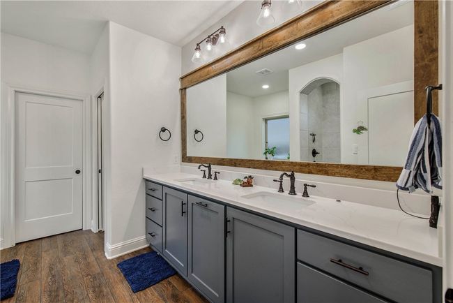 Full bath with a sink, double vanity, wood finished floors, and tiled shower | Image 16