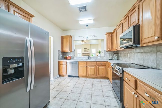 Kitchen with Tile Floors and Backsplash. Smooth cooktop w/oven, microwave, dishwasher and fridge is negotiable. | Image 5
