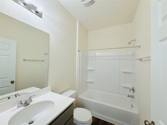 Bathroom with toilet, vanity, shower / bathtub combination, and wood finished floors | Image 10