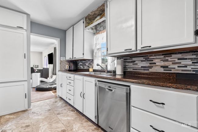 Kitchen with dishwasher, decorative backsplash, and white cabinetry | Image 19