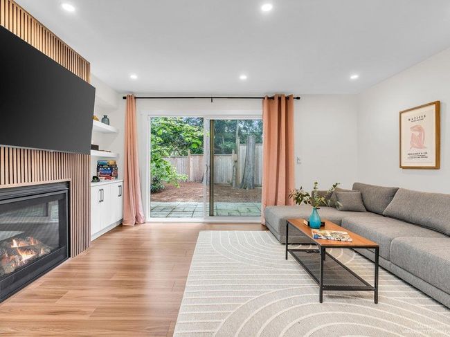 Beautiful newly renovated family room with gas fireplace and statement fireplace surround, built in display shelves as well as enclosed shelving for storage, and beautiful new flooring, all with patio doors to the back yard. | Image 23