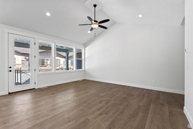 Unfurnished room featuring baseboards, lofted ceiling, recessed lighting, ceiling fan, and dark wood-type flooring | Image 4