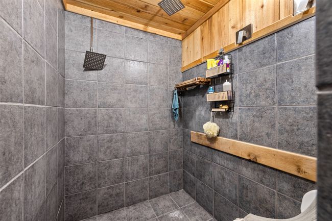 Full bathroom featuring a tile shower and wooden ceiling | Image 38