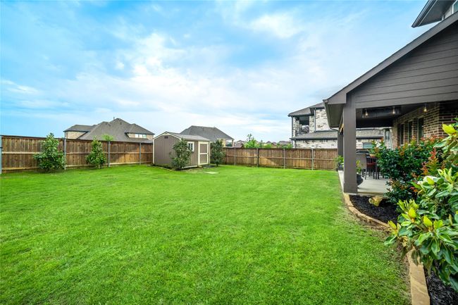 View of yard with a storage unit, an outbuilding, and a patio area | Image 36