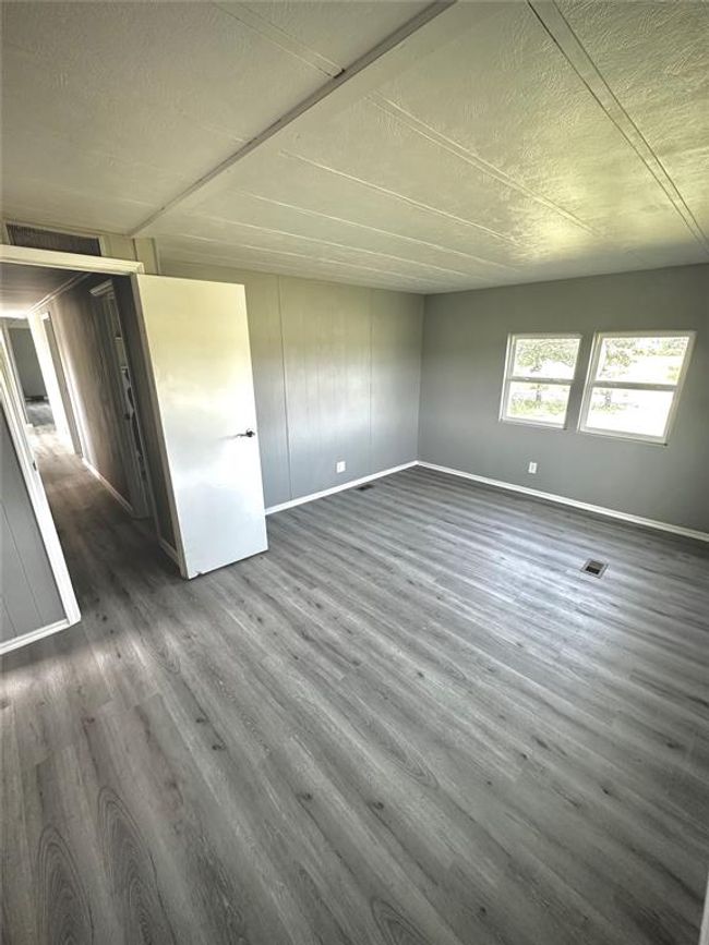 Spare room featuring baseboards, dark wood-style floors, and a textured ceiling | Image 7