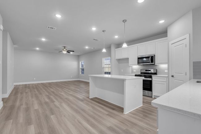 Kitchen with decorative backsplash, visible vents, a ceiling fan, appliances with stainless steel finishes, and white cabinetry | Image 13