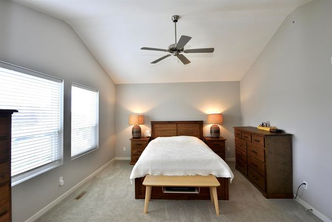 Bedroom featuring vaulted ceiling, light colored carpet, and a ceiling fan | Image 24