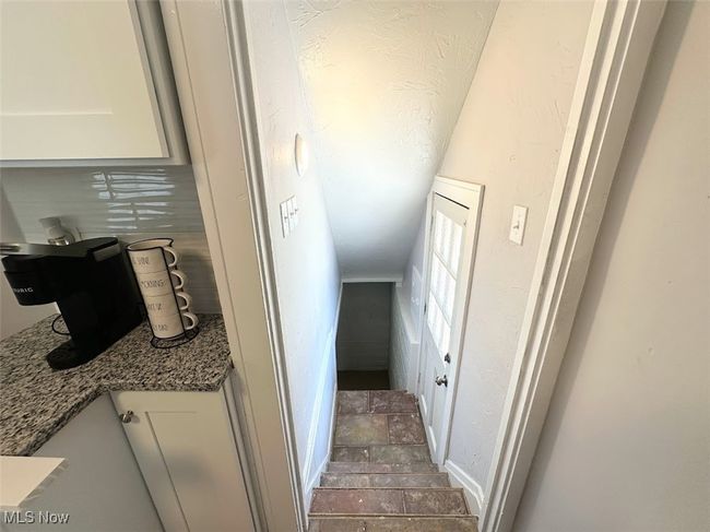 Staircase with stone finish floor and baseboards | Image 12