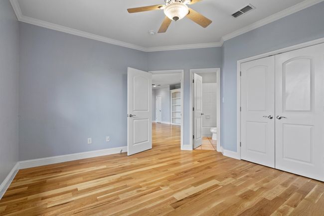 Inviting guest bedroom featuring elegant wood flooring, plenty of natural light from the windows, and a private attached bathroom for added comfort and convenience. | Image 26
