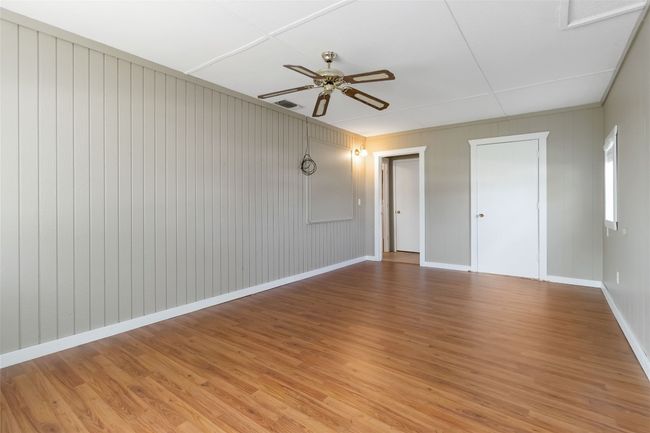 Spare room featuring baseboards, ceiling fan, visible vents, and light wood-style floors | Image 14