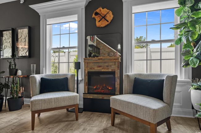 Sitting room with wood finished floors and a glass covered fireplace | Image 9