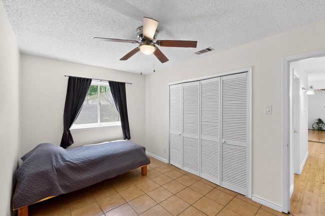 Bedroom featuring a closet, a textured ceiling, and ceiling fan | Image 9