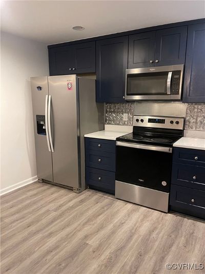 Kitchen with backsplash, stainless steel appliances, and light hardwood / wood-style floors | Image 3