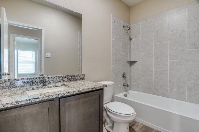 Full bath with shower / washtub combination, wood finished floors, vanity, and toilet | Image 11