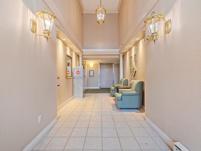 Corridor with light tile patterned flooring, crown molding, a baseboard radiator, baseboards, and ornate columns | Image 19