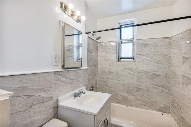 Full bath with vanity, tile walls, and shower / bathtub combination | Image 10