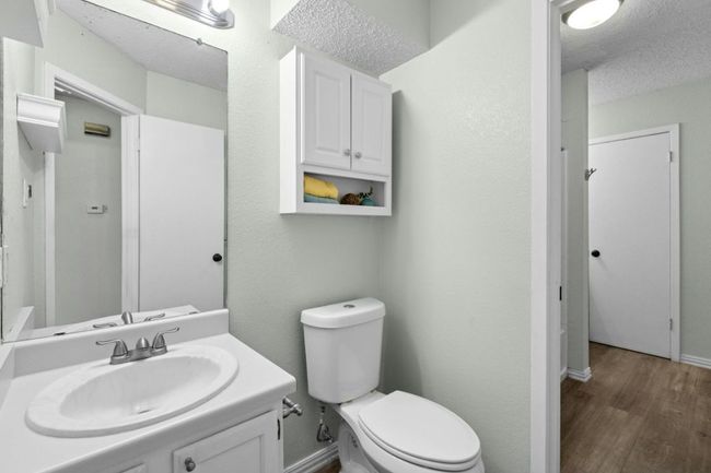 Half bathroom with vanity, a textured ceiling, and wood finished floors | Image 28