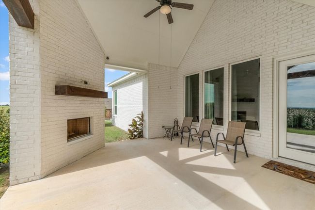 Large patio with an outdoor fireplace and ceiling fan | Image 29