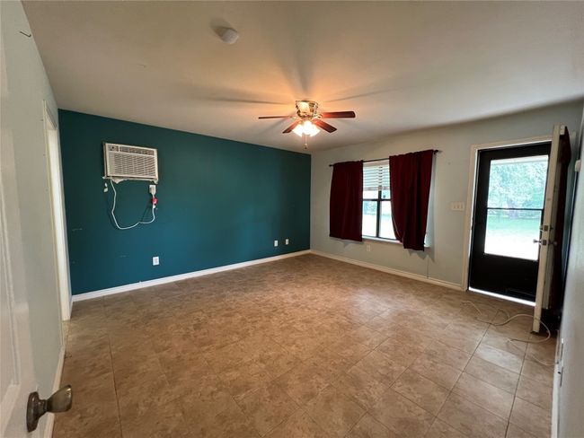 Unfurnished room featuring a ceiling fan, an AC wall unit, and baseboards | Image 19