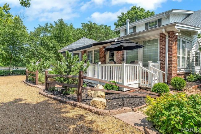 View of front of house featuring brick siding and a wooden deck | Image 4