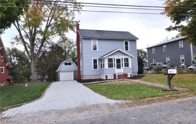 View of front of home with a garage, an outdoor structure, and a front lawn | Image 1