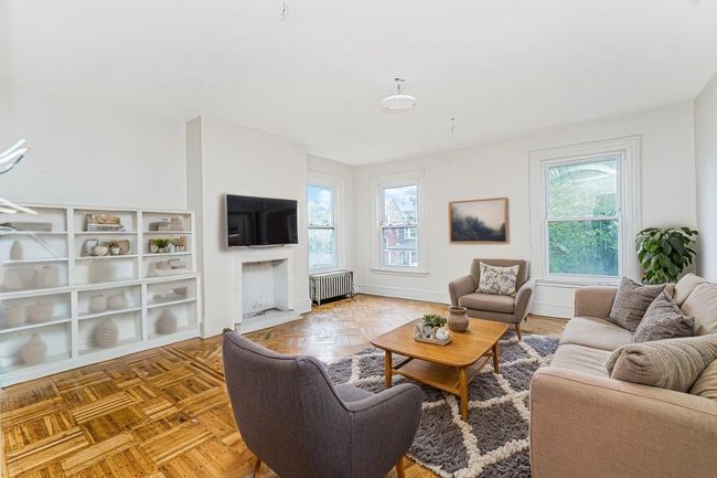 Living room with radiator heating unit and healthy amount of natural light | Image 11