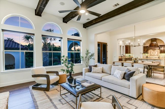 Living area featuring, wood beamed ceiling, and mesquite hardwood flooring, with fireplace and built in cabinetry. Beautiful open floor plan with architectural designs througout the home | Image 6