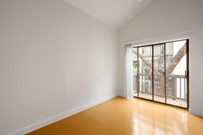 Spare room with baseboards, high vaulted ceiling, and finished concrete floors | Image 11