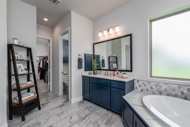 Full bathroom with vanity, toilet, a garden tub, marble finish floors, and baseboards | Image 17