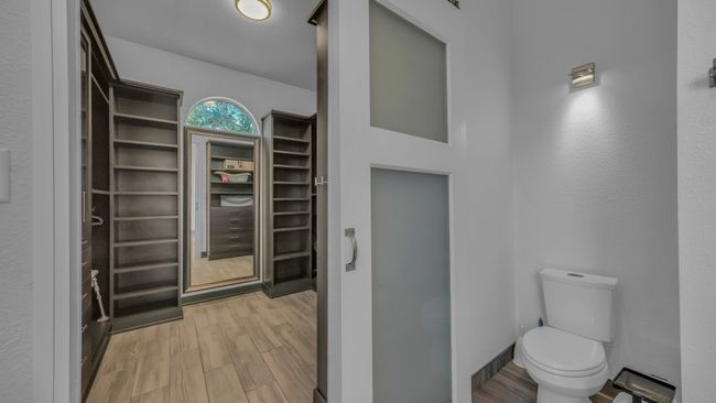 Bathroom featuring a walk in closet and wood finished floors | Image 23