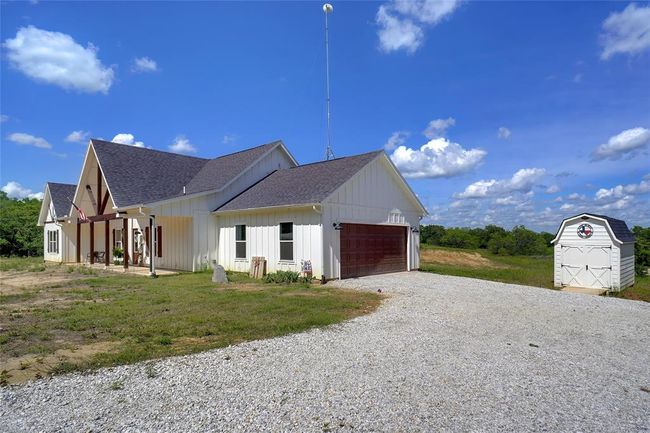 View of side of property with a garage, a lawn, and a storage shed | Image 3