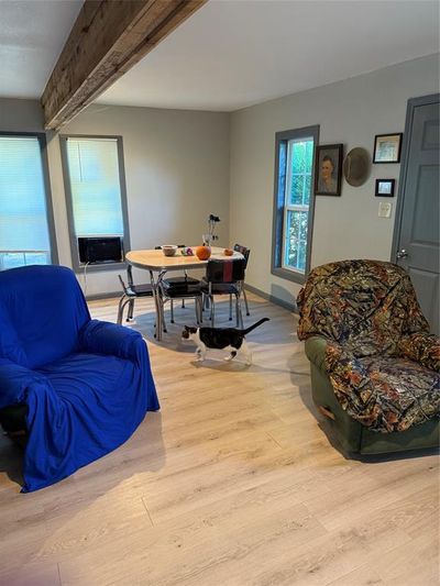 Living room featuring light hardwood / wood-style floors, cooling unit, and beamed ceiling | Image 3