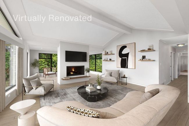 Living room featuring lofted ceiling with beams, baseboards, a warm lit fireplace, and wood finished floors | Image 10