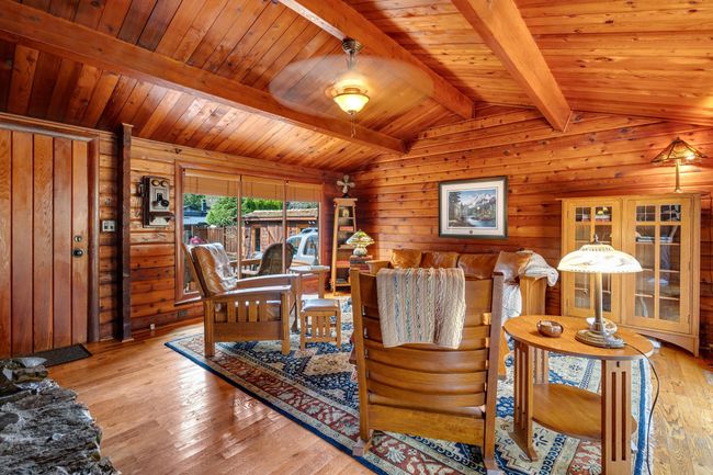 Living area with wooden walls, hardwood / wood-style floors, and wooden ceiling | Image 6