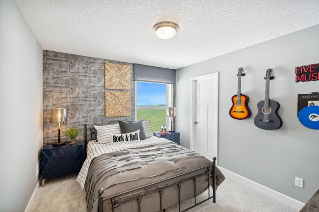 (Photo of a decorated model, actual homes finishes will vary) The second generously sized upper level secondary bedroom with a spacious closet. | Image 18