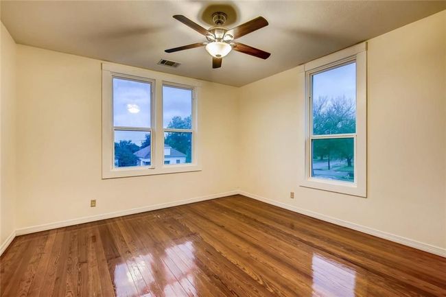 Spare room featuring dark wood finished floors, baseboards, and ceiling fan | Image 15