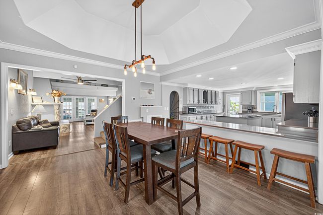 Dining space with healthy amount of natural light, dark wood-style flooring, ceiling fan, arched walkways, and recessed lighting | Image 30