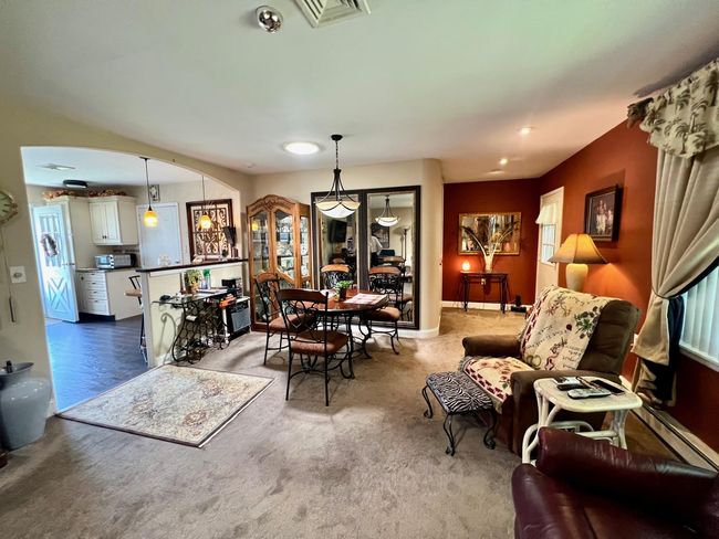 Dining area with arched walkways, carpet floors, and a baseboard heating unit | Image 9